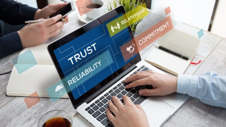 Egy laptop képernyőjén a bizalom és megbízhatóság fogalmai láthatók, miközben egy ember gépel.